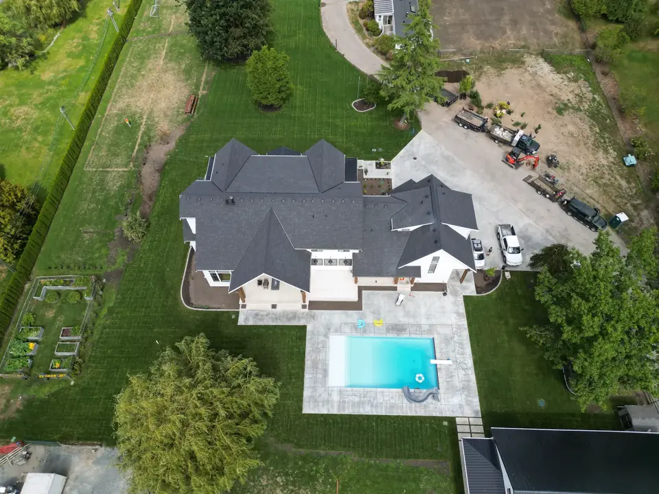Aerial view of a luxury landscape design with pool, lawns, and established garden beds